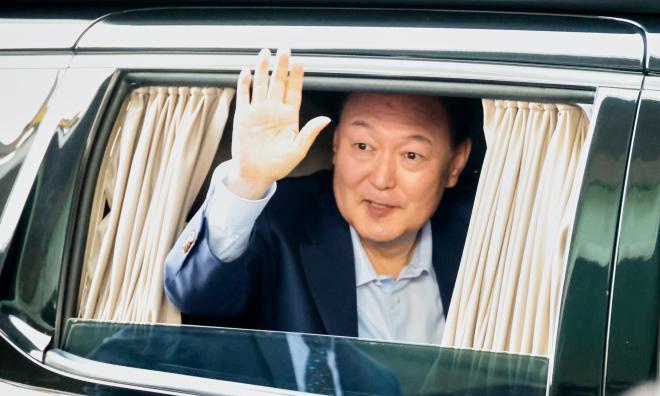 Sydkoreas avsatte president Yoon Suk-Yeol vinkar till sina anhängare. Bilden togs i fredags.