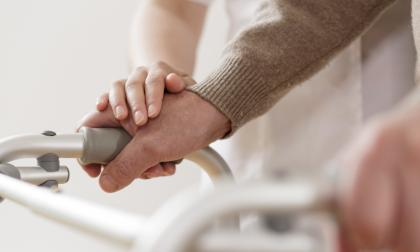 Close-up of physiotherapist supporting disabled senior man