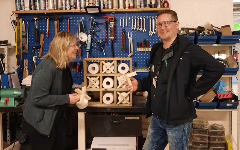 Idékläckaren Elinda Fredman i ivrig diskussion med verkställaren Markus Öhman angående detaljerna på det senaste projektet toapappershållaren, även den gjord av lastpallar.