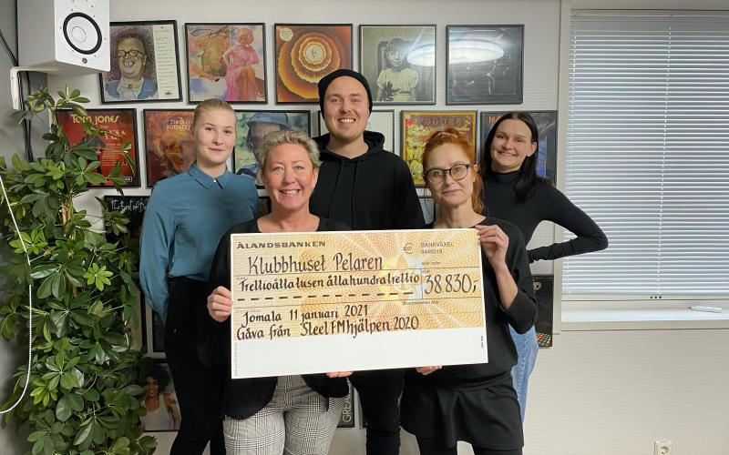 Här överlämnar Eva Karlström checken till Myra Forsström på Klubbhuset Pelaren.