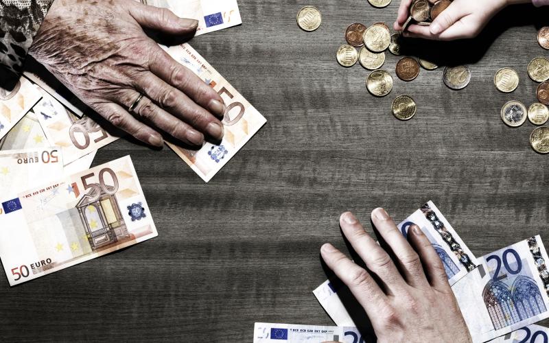 3 generations of hands with euro coins and notes on table