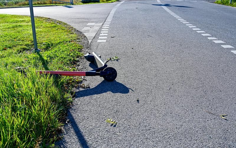 electric scooter lying on tarmac and grass in Orebro Sweden