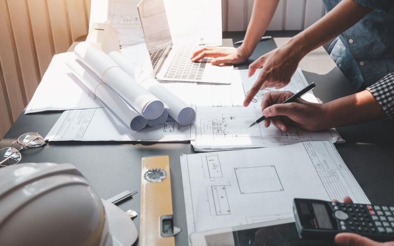 Architect man engineer construction concept using blueprints at the office.